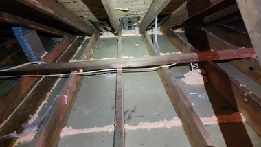 Attic floor showing gaps and penetrations before air sealing