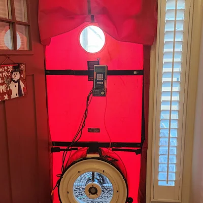 Blower door fan and manometer installed in interior doorway during air leakage test